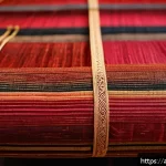 태국의 전통 직조 기술 - A vibrant close-up of traditional Thai silk fabric called "Si Lom" from Northern Thailand, showcasin...